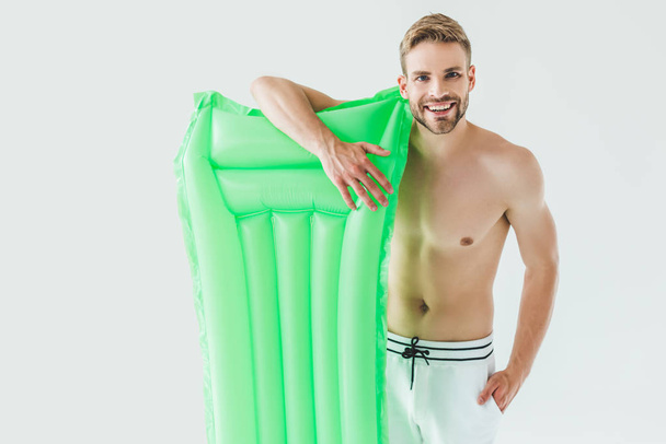 handsome smiling man posing with inflatable mattress, isolated on white - Foto, immagini