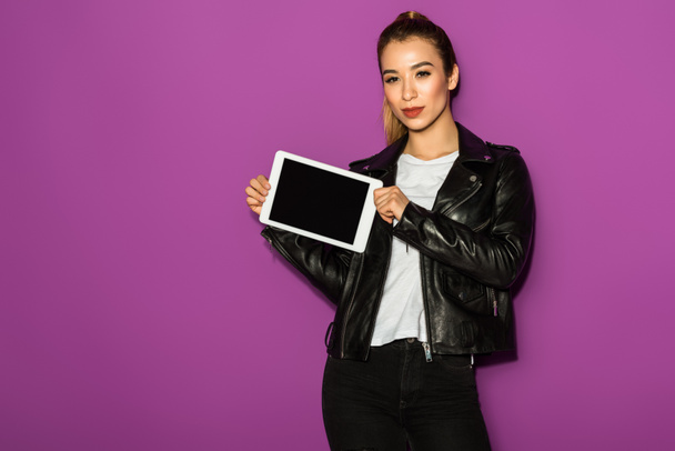 bella giovane donna asiatica in possesso di tablet digitale con schermo bianco e guardando la fotocamera isolata su viola
 - Foto, immagini
