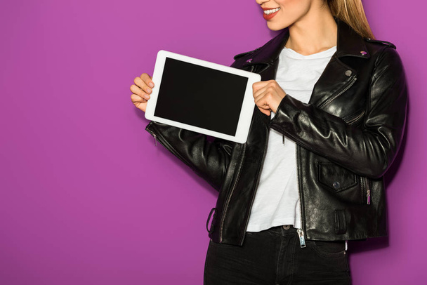 cropped shot of smiling young woman holding digital tablet with blank screen isolated on violet - Фото, изображение