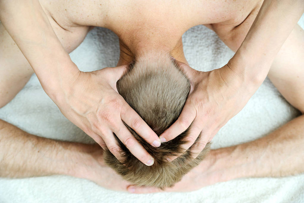 Gezondheid massagetherapie. Vrouwelijke handen zijn het masseren van de man hoofd. - Foto, afbeelding