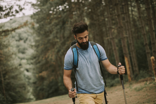 Portrait of young bearded man hiking alone on mountain - Photo, Image