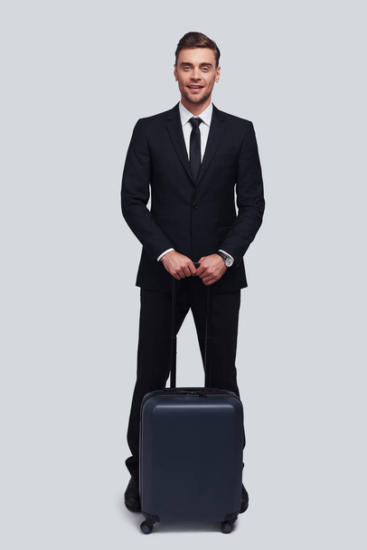 full length of businessman with suitcase in studio - Foto, imagen