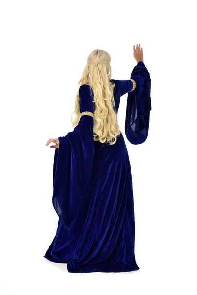 tam uzunlukta bir mavi fantezi Ortaçağ elbisesi giymiş güzel sarışın kadın portresi. Beyaz arka plan üzerinde ayakta poz. - Fotoğraf, Görsel