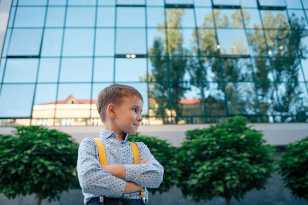 Chłopiec z skrzyżowanymi rękami przed centrum biznesowe - Zdjęcie, obraz