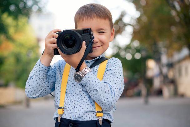 Boy makes pictures on film retro style digital camera - Photo, Image