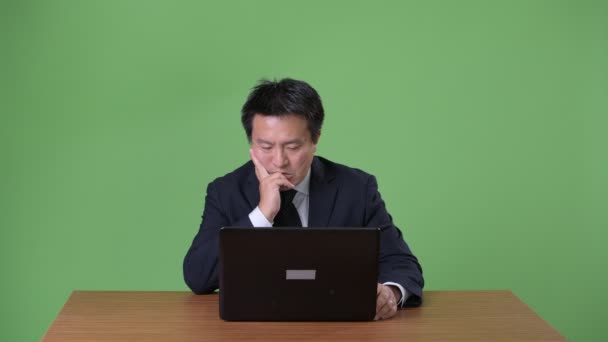 Ώριμη ιαπωνική επιχειρηματίας ενάντια σε πράσινο φόντο - Πλάνα, βίντεο