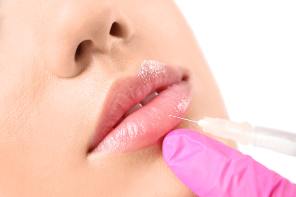 Young woman getting lip injection in beautician salon, closeup - Zdjęcie, obraz