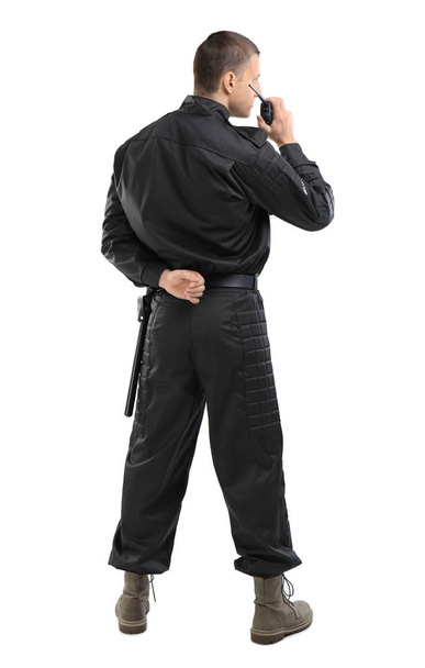 Male security guard using portable radio transmitter on color background - Foto, immagini