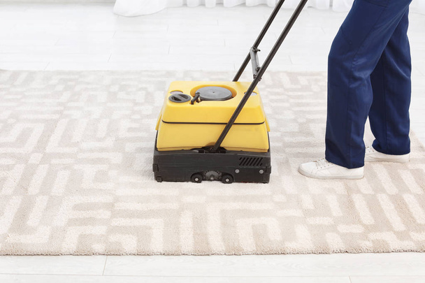 Male worker with carpet cleaner indoors, closeup - 写真・画像