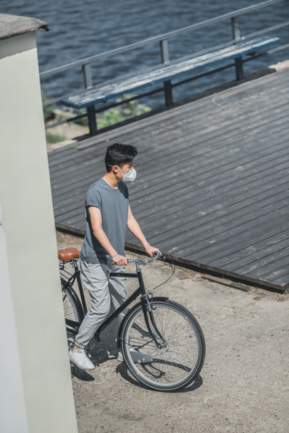 high angle view of asian teen in protective mask standing with bicycle, air pollution concept - Valokuva, kuva