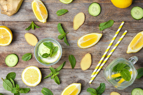 Flat lay composition with detox lemonade and ingredients on wooden background - Fotoğraf, Görsel