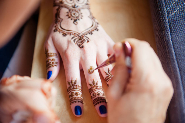 Drawing mehndi on the hand of a girl - Фото, изображение