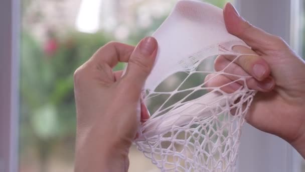 Close-up. Vrouwelijke handen test de integriteit van kapron kousen. een gescheurde panty, 4k, slow-motion - Video