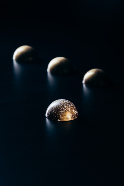 close up image of chocolate candies on black background  - Фото, изображение