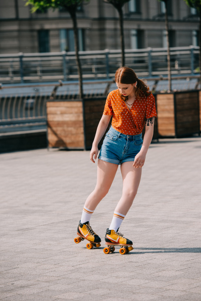 beautiful girl in denim shorts roller skating on street - Φωτογραφία, εικόνα