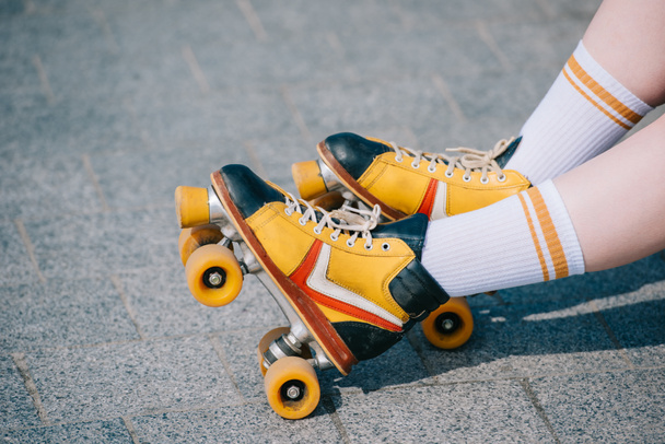 close-up partial view of female legs in vintage roller skates - 写真・画像