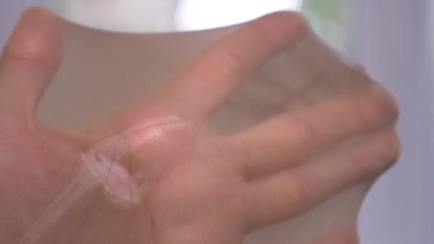 Close-up. Vrouwelijke handen test de integriteit van kapron kousen. een gescheurde panty, 4k, slow-motion - Video