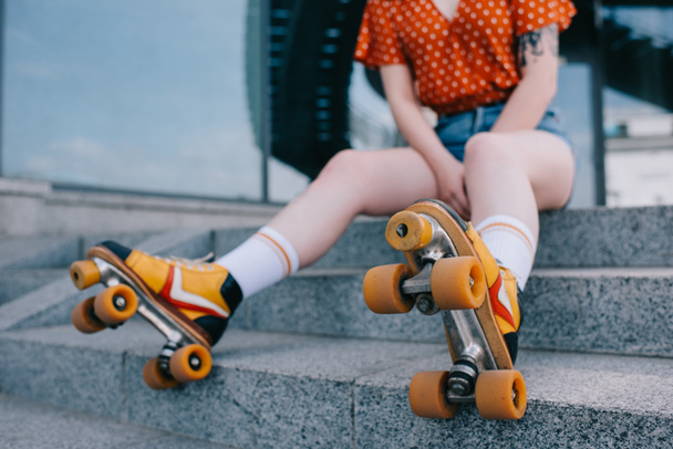 cropped shot of stylish young woman in roller skates sitting on stairs - Foto, immagini