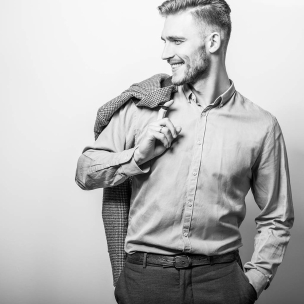 Handsome young elegant man in grey jacket pose against studio background. Black-white photo. - Fotografie, Obrázek