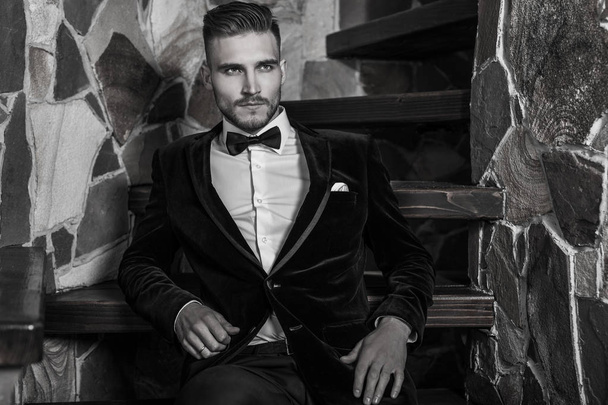 Handsome young elegant man pose against house interior. Black-white portrait. - Photo, image