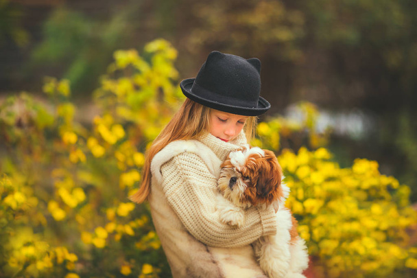 Cute little girl with a love of looking at a puppy - Fotoğraf, Görsel