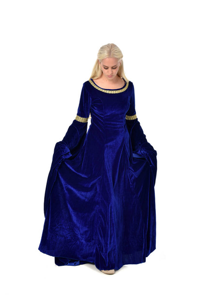 retrato de comprimento total de senhora loira bonita vestindo um vestido medieval fantasia azul. postura em pé sobre fundo branco
. - Foto, Imagem