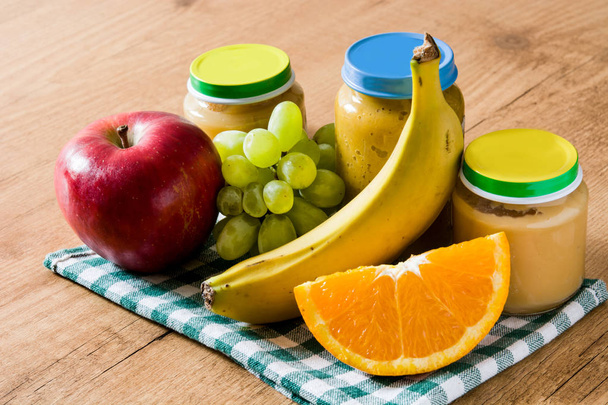 Дитяча їжа: Яр з фруктовим пюре на дерев'яному столі
 - Фото, зображення
