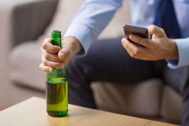 close up of man with smartphone and beer bottle - Foto, immagini
