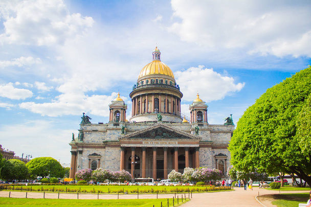 Saint Isaac's Cathedral (Isaakievskiy Sobor) in the flowers of lilac and Apple trees - Фото, изображение