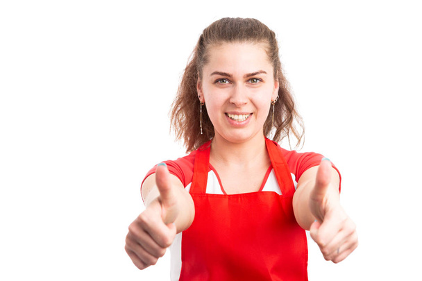 Mujer joven empleado de supermercado mostrando pulgares hacia arriba como gesto como concepto minorista feliz aislado en fondo blanco
 - Foto, imagen