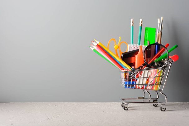 Small shopping cart with various school supplies - Foto, afbeelding