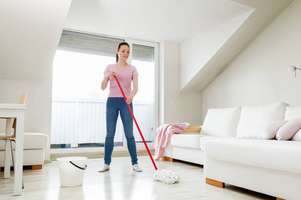 woman or housewife with mop cleaning floor at home - Foto, Imagen