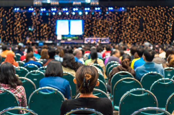 Задний вид аудитории в конференц-зале или на семинаре, где выступают спикеры на сцене, в бизнесе и образовании об инвестиционной концепции
 - Фото, изображение