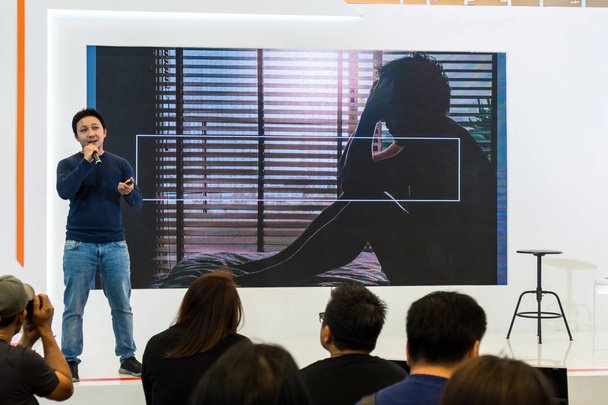 азиатский спикер в повседневном костюме на сцене за экраном презентации в бизнес-семинаре или образовательном семинаре
 - Фото, изображение