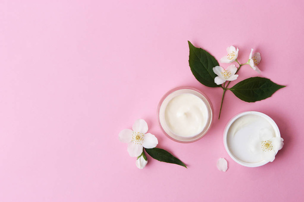 un barattolo di crema cosmetica con fiori su sfondo colorato.minimalismo, top
 - Foto, immagini