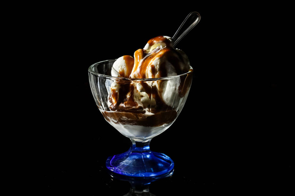 Ice cream plombier with caramel topping on a black background - 写真・画像