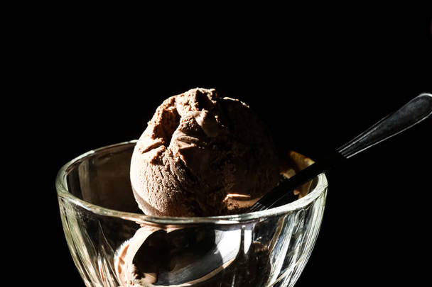 Chocolade-ijs in een beker op een zwarte achtergrond - Foto, afbeelding