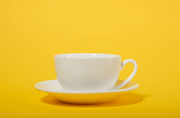 one simple coffee cup on yellow color background, closeup photo - Photo, Image