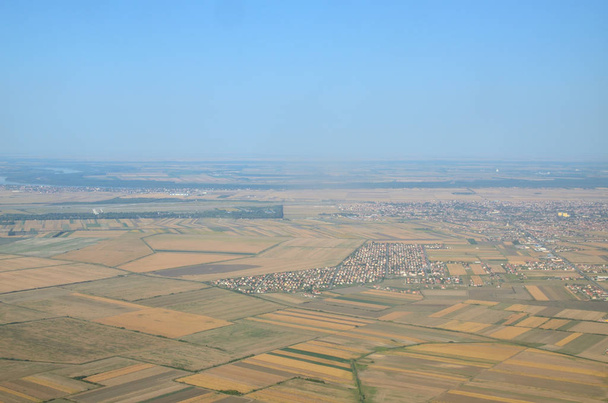 Weizenfelder, Ebenen mit verschiedenen Pflanzen und ein Vorort der Stadt vom Landeflugzeug aus gesehen - Foto, Bild