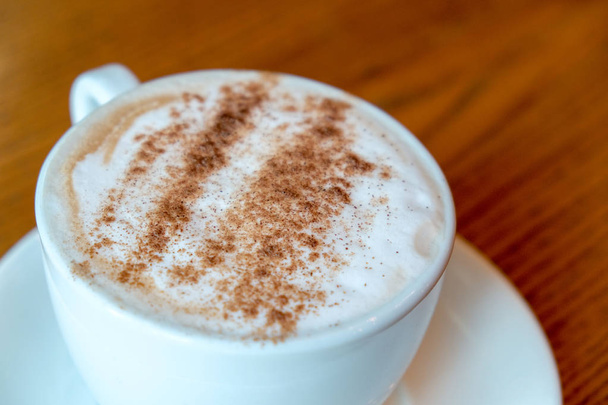 Közeli kép: kávé fa háttér fehér csészében. Szemközti nézet - Fotó, kép