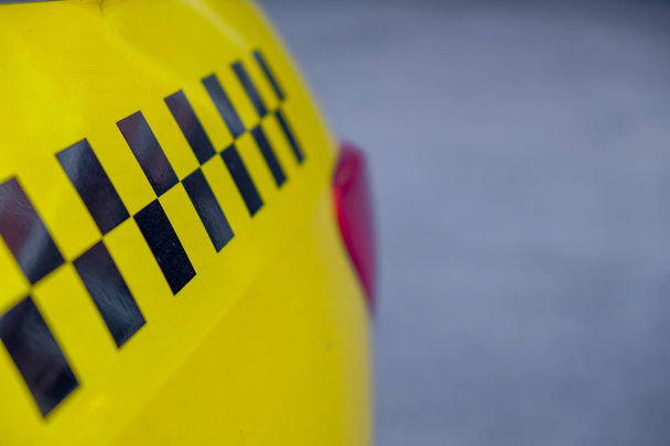 Жёлтое такси с чёрными квадратами
 - Фото, изображение