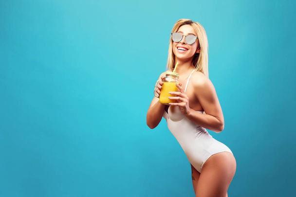 Woman in bodysuit with juice in the jar - Valokuva, kuva