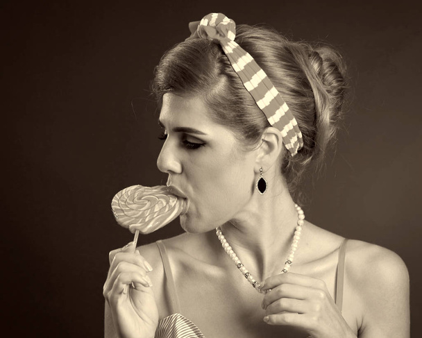 Žena jíst cukroví. Dívka v pin-up stylu drží pruhované cukroví. - Fotografie, Obrázek