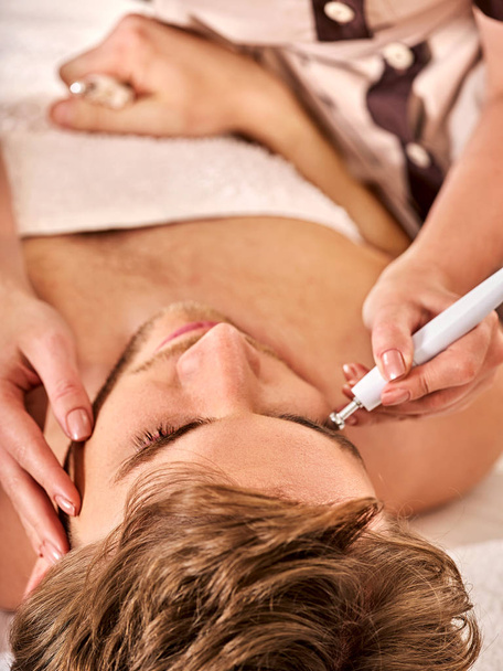 Massage facial au salon de beauté. Électrique stimulation homme soin de la peau
. - Photo, image