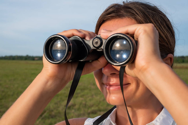 Woman use of the binoculars for looking up - Photo, Image