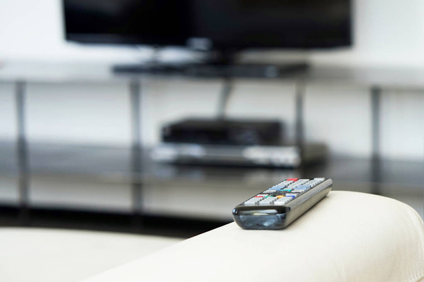Control remoto de TV en el sofá interior, primer plano. Cine en casa
 - Foto, imagen