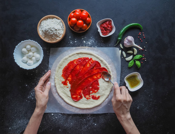 Produktion italienischer Pizza margarita. Produktionsphase. Tomatensauce, Mozzarella und Tomaten. - Foto, Bild