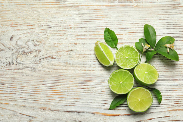 Composition with fresh ripe limes on wooden background, top view - Foto, Bild