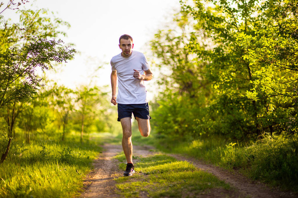  Urheileva nuori mies juoksee luonnossa. Terveellinen elämäntapa
 - Valokuva, kuva
