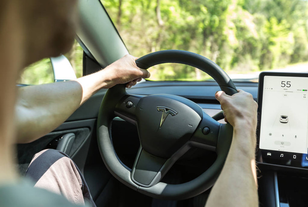 Person driving a new Tesla Model 3 - Foto, immagini